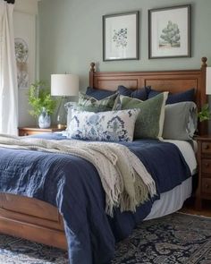 a bedroom with blue and white bedding, two pictures on the wall above the bed