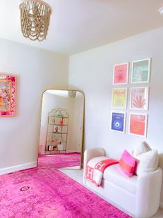 a living room filled with furniture and pink rugs on the floor next to a mirror