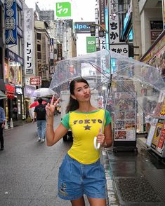 a woman is holding an umbrella on the street