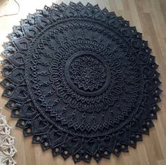 a black doily sitting on top of a wooden floor