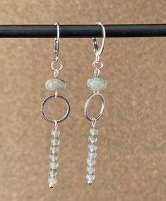 These drop earrings are handcrafted with labradorite gemstones. A 6mm rondelle stone is the focal point. From the stone hangs a 12 mm silver plated ring which holds a labradorite bar pendant made up of seven 4 mm stones. The overall length is 2.5 inches. The earring style is a hypoallergenic stainless steel lever back. Faceted Labradorite Dangle Jewelry, Sterling Silver Gray Dangle Jewelry, Gray Sterling Silver Dangle Earrings, Gray Sterling Silver Dangle Jewelry, Minimalist Gray Sterling Silver Jewelry, Ear Rings, Bar Pendant, Handcrafted Earrings, Plated Ring