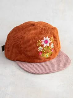 Cap off your look with this super cool and easy corduroy snapback! With color contrast on the bill and the adjustable strap on the back, this hat brings a fun, vibrant addition to any outfit. The cute embroidered designs on the front add a touch of personality, while the unstructured style gives it a relaxed and laid-b Trendy Embroidered Cotton Snapback Hat, Colorful Granola Outfits, Trendy Corduroy Snapback Baseball Cap, Trendy Corduroy Snapback Hat, Floral Embroidery Cotton Snapback Hat, Corduroy Hats, Granola Fits, Granola Outfits, Folk Flowers