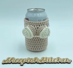 a crocheted coffee cup holder with an owl on it and the words sheepish stitches written below