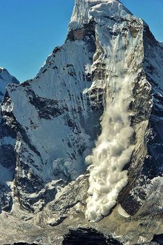 the mountain is covered in steam as it rises into the air with snow on top