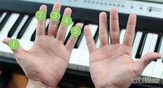 two hands with green numbers on them near a piano keyboard and an electronic keyboard in the background