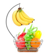 a metal basket filled with lots of different types of fruit next to a hanging banana