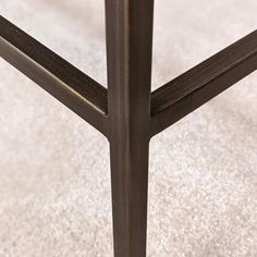 a close up view of a metal and wood table with a white rug on the floor