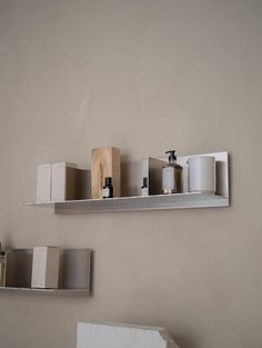 two shelves with various items on them in a room that is painted light gray and white