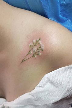 a close up of a person's stomach with small flowers on the side of her belly