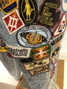 the back side of a pair of jeans with patches and stickers all over it