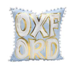 a blue and white pillow with gold foil lettering