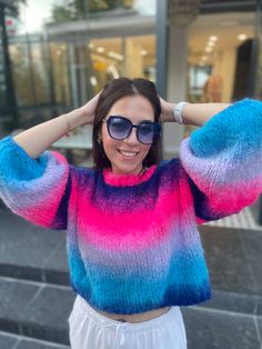 a woman wearing sunglasses and a colorful sweater