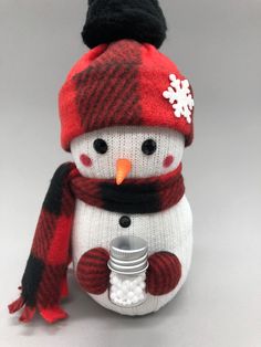 a stuffed snowman with a scarf, hat and mitten on it's head