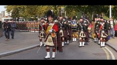 a group of men in kilts marching down the street