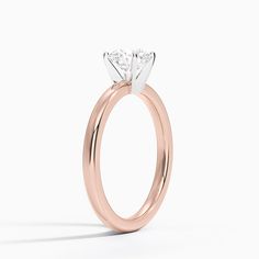 a rose gold engagement ring with a single diamond in the center, on a white background