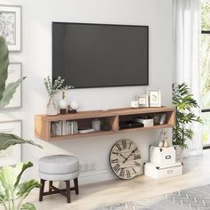 a flat screen tv mounted to the side of a wall next to a wooden shelf