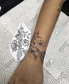 a woman's foot with a flower tattoo on her left arm and the bottom part of her leg