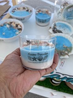 a hand holding a cup filled with blue liquid