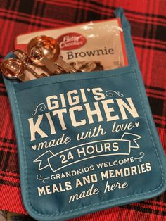 there is a teal colored bag with some kitchen items in it that says girls kitchen made with love 24 hours meals and memories made here