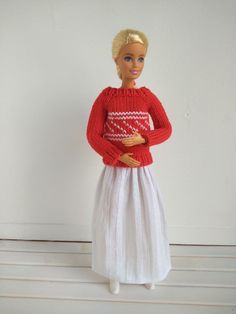 a barbie doll wearing a red sweater and white skirt with her hands on her hips