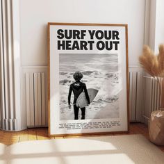 a surfboarder is holding his board in front of a poster that reads surf your heart out