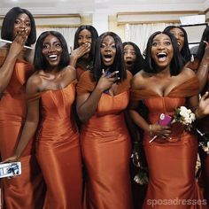 a group of women standing next to each other in front of a mirror holding up their cell phones