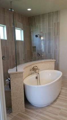 a large white bath tub sitting inside of a bathroom next to a walk in shower