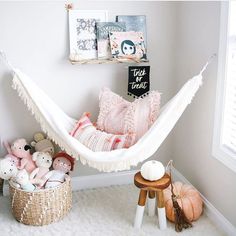 a white hammock in a child's room with stuffed animals and toys