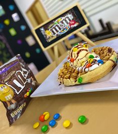 an ice cream sundae is on a plate with candy