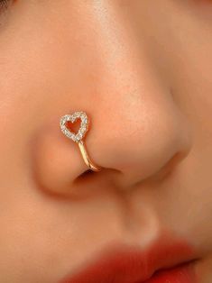 a woman with a heart shaped nose piercing on her nose and the end of her nose is