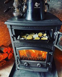 an old fashioned stove with some lemons on it's burners and logs