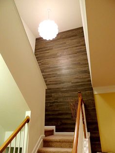 stairs leading up to the second floor in a house with wood paneling on the walls