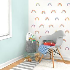 a child's room with a chair, rug and rainbow wallpaper