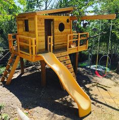 a wooden play structure with a slide in the foreground