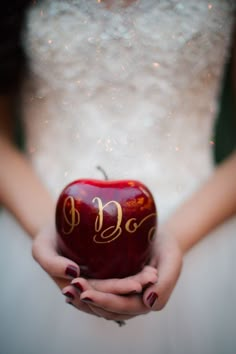 a woman holding an apple in her hands with the letter b on it's side