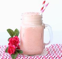 a pink drink in a mason jar with two straws