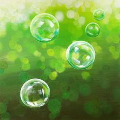 three soap bubbles floating in the air on a green background with blurry boke