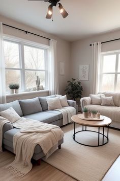 a living room with two couches and a coffee table in front of the window