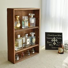 a wooden shelf filled with bottles next to a window