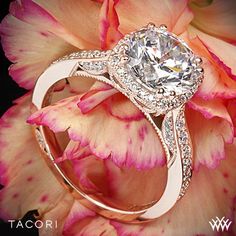 a diamond ring sitting on top of a flower with the words tacori written below it