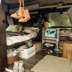 a room filled with lots of clutter and shoes hanging from the ceiling next to a bed