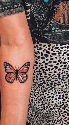 a woman's arm with a butterfly tattoo on the left side of her body