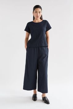 Product Details The Huvet Top features a classic cap sleeve and elegant round neckline. Offered in New Navy, the luxurious textured organic cotton from which it is crafted offers unrivalled movement and visual interest. Designed with a standard body length to allow for versatile styling. Create a coordinated ensemble by tucking the Huvet Top into the Huvet Pants. Made in Organic Cotton - an ELK preferred fibre. Textured cotton blend fabric offers breathability and movement to the garment. Design Ponte Pants, Athleisure Fashion, Knitwear Cardigan, Little Dresses, Knee Length Dresses, Cropped Cardigan, Summer Hats, Clothing Co, Knit Jumper