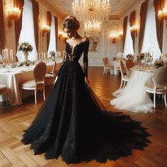 a woman in a long black dress is standing near a table with white tables and chandeliers