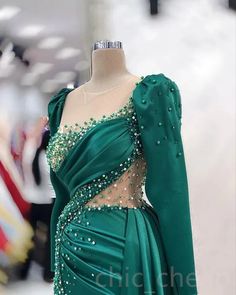 Elevate your evening glam with this exquisite emerald green gown, masterfully designed to make a statement. The dress features a luxurious satin fabric that drapes elegantly over the body, complemented by intricate beadwork and delicate sequins that add the perfect touch of sparkle. The asymmetrical neckline and sheer illusion mesh panels create a unique and captivating silhouette, making this gown the ultimate choice for any formal occasion.Designed with both style and comfort in mind, the gown Green Sequined Evening Dress For Banquet, Green Sequined Evening Dress For Banquets, Green Satin Evening Dress For Gala, Green Satin Gown For Banquet, Embellished Green Gown For Banquet, Glamorous Green Evening Dress With Sweep Train, Green Satin Evening Gown, Glamorous Green Gown For Banquet, Glamorous Green Satin Gown