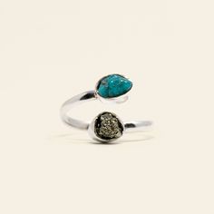 Embark on a transformative journey with our Turquoise & Pyrite Bypass Ring, meticulously crafted to elevate your spiritual practice. Crafted from sterling silver, this ring intertwines the calming essence of Turquoise with the protective aura of Pyrite, creating a harmonious synergy that nurtures, shields, and amplifies positive energies. Key Benefits & Features: Genuine Precious Gemstones: Crafted with visually striking Turquoise and Pyrite for a potent energetic resonance. Superior Craftsmansh Spiritual Open Ring With Stones, Spiritual Turquoise Open Ring For Gift, Adjustable Spiritual Turquoise Open Ring, Spiritual Natural Stones Opal Open Ring, Adjustable Nickel-free Turquoise Open Ring, Bypass Rings, Original Engagement Rings, Creative Problem Solving, Gemstone Properties