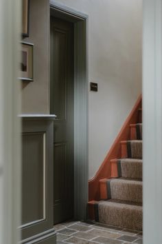 an open door leading to a set of stairs with carpet on the floor and walls