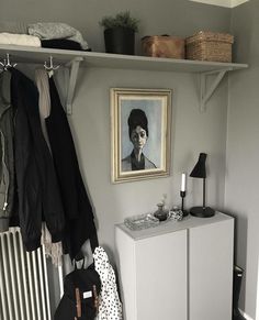 a white cabinet sitting next to a radiator under a painting on the wall