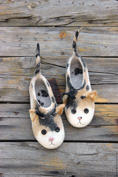 pair of slippers with cats on them sitting on wooden planks in the grass