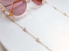 Dainty gold colour Zirconia star glasses chain, Delicate sunglasses chain, Travel essential gift for mother, Valentines Gift for her Lanyard 🌟length: approx 70cm 🌟they will be packaged into a reusable sealed bag. 🌟Glasses not included 🌟Shipment:  Standard (Free): untrackable Royal mail 2nd class (2-3 working days)  OR upgrade to 1st class/ trackable service when placing orders. :) ------------------------------------ ❤️For more necklaces https://www.etsy.com/uk/shop/LuluxStudio?section_id=40089585 ❤️For more rings https://www.etsy.com/uk/shop/LuluxStudio?section_id=40082442 ❤️For more Glasses Chains https://www.etsy.com/uk/shop/LuluxStudio?section_id=40995718 Trendy Adjustable Party Glasses Chains, Trendy Summer Jewelry With Star Charm, Trendy Adjustable Glasses Chains For Party, Trendy Star Charm Jewelry For Summer, Trendy Glasses Chain As Gift, Trendy Adjustable Glasses Chains As Gift, Chic Adjustable Chain Glasses Chains For Party, Chic Adjustable Glasses Chains For Party, Chic Adjustable Glasses Chain For Parties